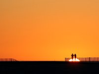 In the Shadows of Figueira: A couple try to photograph the setting sun.  Known as the Queen of the Beaches, Figueira da Foz, Portugal is reknown for its sunny weather.