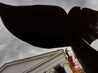 The iconic whale tail sculpture in front of the Whaling Musem looms high above as a worker reparing the roof of the J.J. Best Banc Co. building in downtown New Bedford, can be seen in the background.   PETER PEREIRA/THE STANDARD-TIMES/SCMG