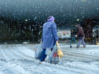 A woman walks across Pleasant Street as heavy snow falls across the region.   PETER PEREIRA/THE STANDARD-TIMES/SCMG