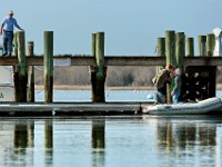 Assistant harbormaster, Clint Allen, left, looks on as Susan Handy wishes husband Edward Handy bon voyage, as he prepares to sail their boat from Mattapoisett, where they store it for the winter, to their home on Marthas Vineyard.   PETER PEREIRA/THE STANDARD-TIMES/SCMG