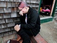 With her four month old baby, Verbena Costa, safe in the entrance behind her, a neighbor offers a hand of support to Amber Bischoff as she weeps after her apartment caught fire at 13 Abbott Street in the south end of New Bedford.   PETER PEREIRA/THE STANDARD-TIMES/SCMG