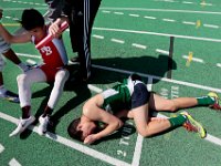 New Bedford high coaches help Ovidio Matos, senior, get up after he and Dartmouth's Greg Martin, junior, both collapse after sprinting to the line in their 2 mile run.  Oivido just won at the line.   Dartmouth High School takes on New Bedford High School track in Dartmouth.   PETER PEREIRA/THE STANDARD-TIMES/SCMG