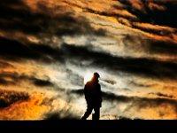 The sun rises behind New Bedford police officer, Scott Tremblay, as he inspects the top of the hurricane barrier walk before crews continue the second phase of the project in the south end of New Bedford. PETER PEREIRA/THE STANDARD-TIMES/SCMG