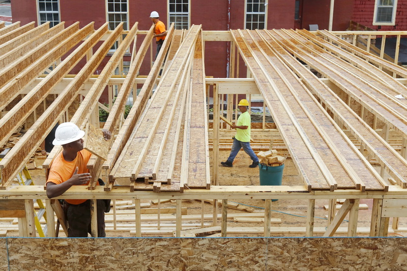 South Coast Improvement Company workmen install the framing for the roof, as another works on the wall framing below, for the new YWKids center and the Women's Single-Occupance Housing addition being constructed next the the YWCA on South Sixth Street in New Bedford, MA. PHOTO PETER PEREIRA