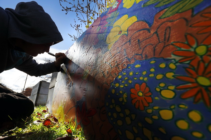 Trinity Day School students install and sign a mural they painted with assistance from Dena Haden from SUPERFLA, and the Co-Creative Center, as part of a Grow Education Harvest Celebration run by the Marion Institute.  The mural was installed outside of their school on the side of one of the planters in New Bedord, MA.  PHOTO PETER PEREIRA