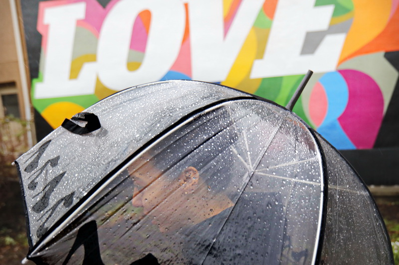 Kimberly Alvarado is protected by a clear umbrella while walking across Wings Court in downtown New Bedford, MA as heavy rains sweep across the region  PHOTO PETER PEREIRA