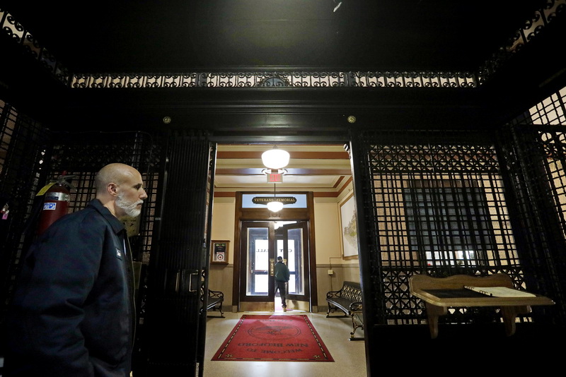 New Bedford City Hall elevator operator, Lane Wood, left, waits for someone to take a ride aboard one of the oldest (1906) running elevators in the country, as someones is seen leaving the historical building in the background.    PHOTO PETER PEREIRA