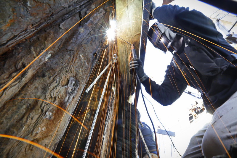 Alix Butters sends sparks flying as he welds a grounding bar for the new anodes he and fellow New Bedford Port Authority workers are installing on the perimeter of the city's docks to keep rusting to a minimum. 