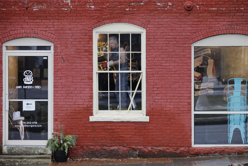 Bob Rooney is seen painting the window frames inside dNB Burgers on Elm Street in New Bedford, MA which is undergoing major interior renovations.    PHOTO PETER PEREIRA