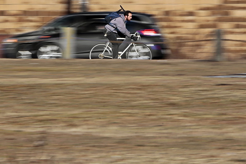 A cyclist streaks across Route 6 as he makes his way toward Fairhaven, MA    PHOTO PETER PEREIRA