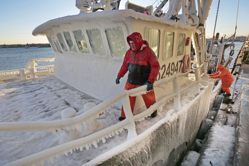 Mike Calen, left, and Steve Goyette, right, prepare to tie off the ice covered fishing boat Buzzards Bay as it arrives to New Bedford harbor due to the extreme cold conditions.   PHOTO PETER PEREIRA