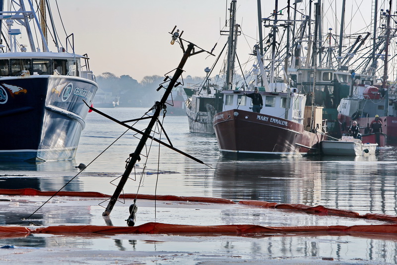 A Tucker-Roy salvage crew moves toward the sunk lobster boat, Moonraker, which sank overnight while docked in New Bedford harbor.     PHOTO PETER PEREIRA