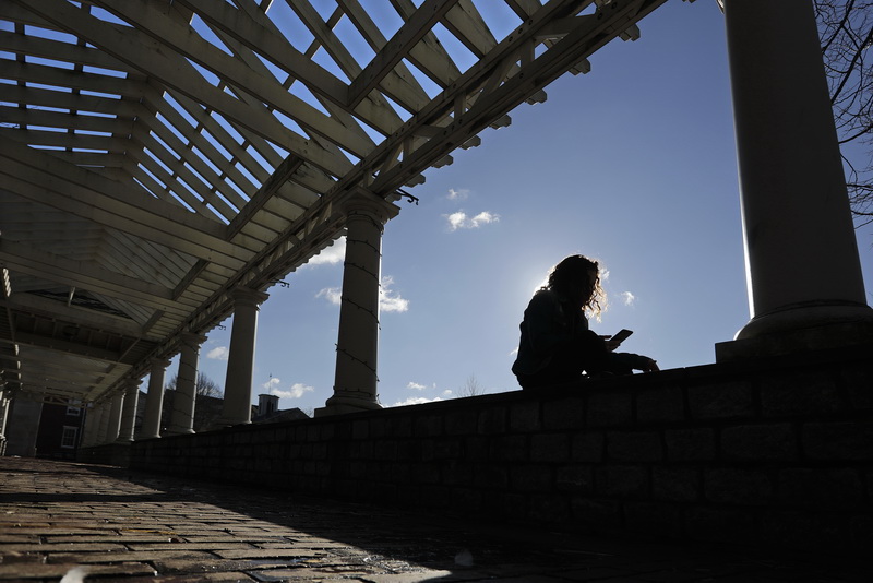 Destiny Tavares takes a break from work by sitting on the wall of the trellis walk at Custom House Square in downtown New Bedford, MA. PHOTO PETER PEREIRA