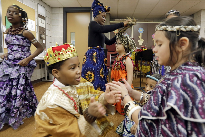 Gomes School teacher, Rena Douglas, puts the final touches on the west African dresses being worn by students before a fashion show celebrating Black History Month at the Gomes School in New Bedford, MA.  PHOTO PETER PEREIRA