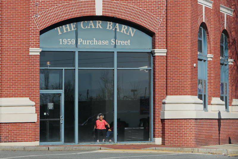 A resident of The Car Barn residential complex on Purchase Street in New Bedford, MA, enjoys the view and the sunlight from inside the facilitie's conference room area.  PHOTO PETER PEREIRA