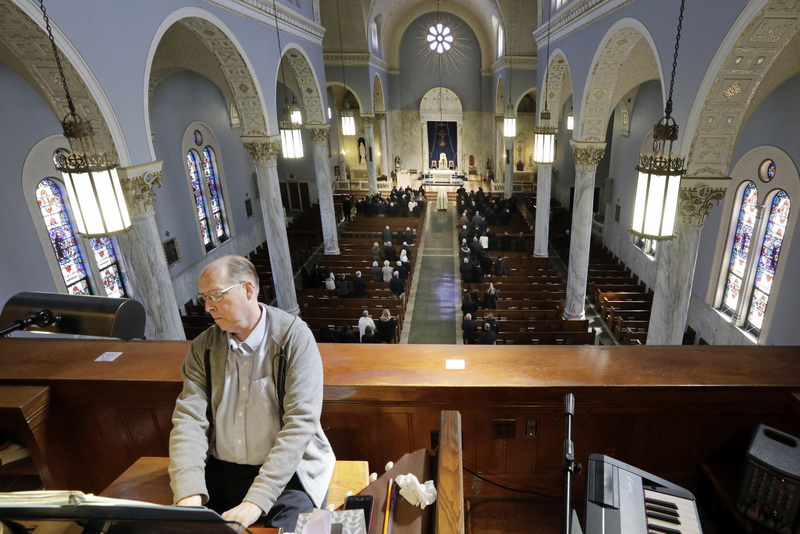 Organist Barry Turley plays a somber classial piece duiring the Funeral Mass of longtime New Bedford police officer Octavio C. 