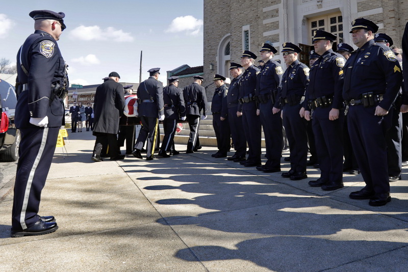 New Bedford police officers stand at attention as the casket of longtime New Bedford police officer Octavio C. 