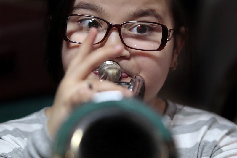 Aiyana Cortes, 10, searches for the right note while practicing her bugle with members of the Cape Verdean Drum ad Bugle Corps at the Verdean Vets Hall on Purchase Street in New Bedford, MA. 