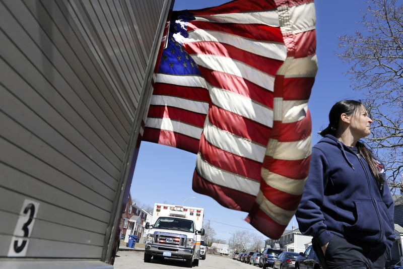 Jolene Menard walks past the American flag that hangs from the back of engine 3, as she makes her way back to the apparatus after responding to a medical emergency in downtown New Bedford.  Jolene Menard is New Bedford fired departments only woman firefighter and is a mother of twins.  This is part of a project I have started to work on recently.  PHOTO PETER PEREIRA