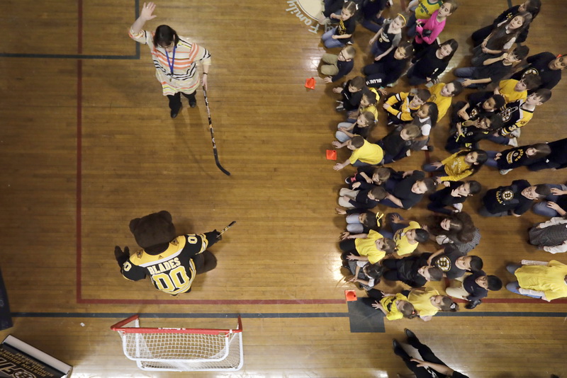 Students look on as a teacher celebrates scoring a goal on Blades the Boston Bruins mascot during his visit to the Holy Family Holy Name school as part of the Boston Bruins Fit School Assembly Program.  The Boston Bruins donated a hockey sticks, nets and goalie gear to the New Bedford, MA school.  PHOTO PETER PEREIRA