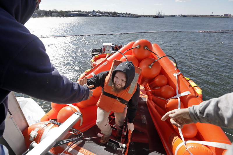 Dan Pryor, left, and Rick Boswell, help a participant climb back up the shute during a training exercise aboard the M/V Nantucket ferry, docked at the Steamship Authority maintenance facility on Main Street in Fairhaven, MA.