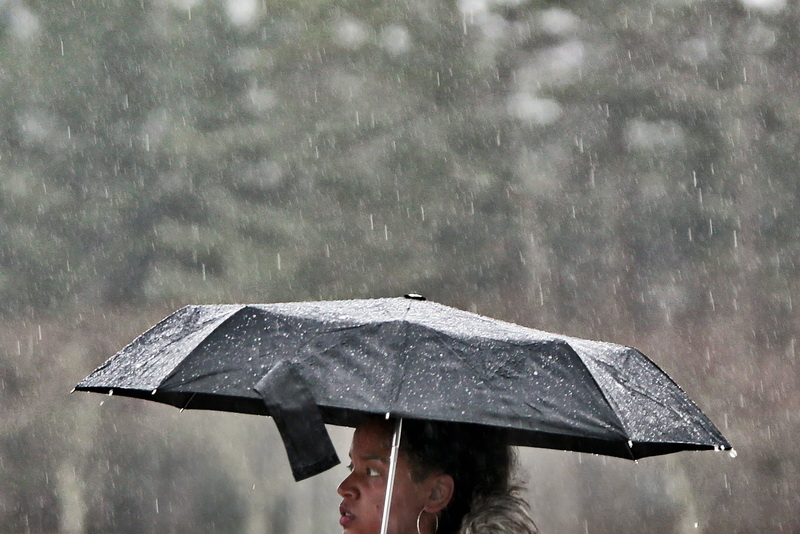 A UMass Dartmouth student is pelted by driving rain as she make her way to class at the Dartmouth, MA campus.   PHOTO PETER PEREIRA