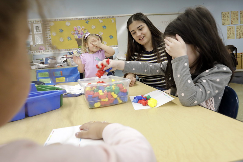 New Bedford High School senior, Maria Faioes, 17, asks pre-school children to close their eyes and grab some figures from a bin which she will have them order by color in the New Bedford High School day-care program for students involved in one of the many vocational programs available in the school.    PHOTO PETER PEREIRA