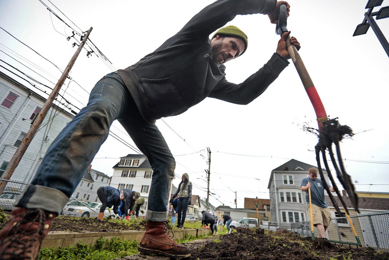 Nate Sander of Round the Bend Farm, tills the soil by hand as he and fellow volunteers from UMass Dartmouth, BCC and Round the Bend Farm, weed and plant various vegetables in the planters in front of the Sister Rose House in New Bedford, MA.  This is part of the Sister Rose Garden Project at the homeless shelter in the south end of the city.  PHOTO PETER PEREIRA