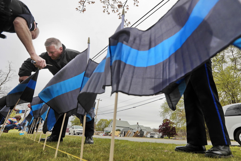 Wareham police officers place 165 Thin Blue Line flags in front of the Wareham Police Station on Cranberry Highway in Wareham, MA in remembrance of 163 officers who died in the line of duty in 2018, and 2  for the two Wareham police officers who were killed in the line of duty (one in 1999 and one in 1932).    PHOTO PETER PEREIRA