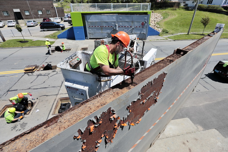 New Bedford DPI's Greg Bairos uses a pneumatic pick to remove the rust from the top edge of the hurricane barrier doors on West Rodney French Boulevard in the south end of New Bedford, MA as part of an annual maintenance routine to the hurricane barrier.    PHOTO PETER PEREIRA