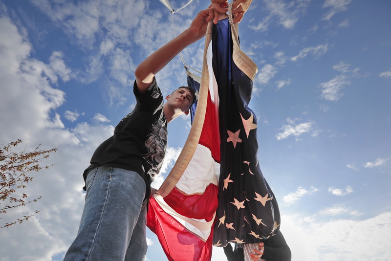 John Mills, 15, and fellow New Bedford High School JROTC students hoist the American flag in front of their school, a ritual they perform every morning before school starts.    PHOTO PETER PEREIRA