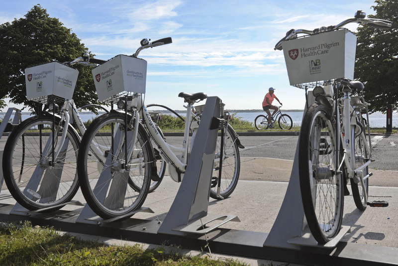 A woman riders her bike past the rows of bicycles available for rent at Fort Taber Park in the south end of New Bedford, MA   PHOTO PETER PEREIRA