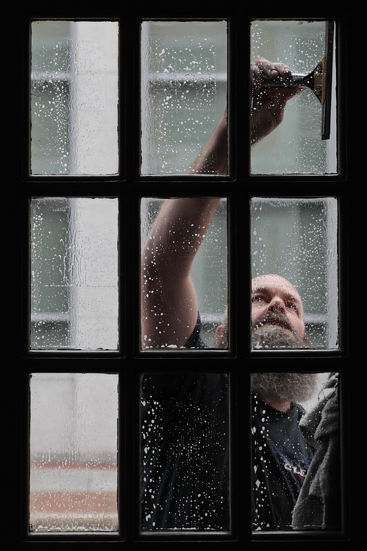 Douglas Cutler of All Clean Window Cleaning is seen cleaning the windows of Tia Maria's European Cafe in downtown New Bedford, MA.