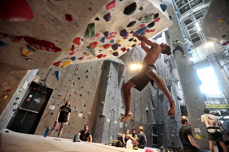 Climbers look on as John Vigeant is supended in the air as he makes his way up an inverted section at Carabiner's Climbing and Fitness in New Bedford, MA.  PHOTO PETER PEREIRA