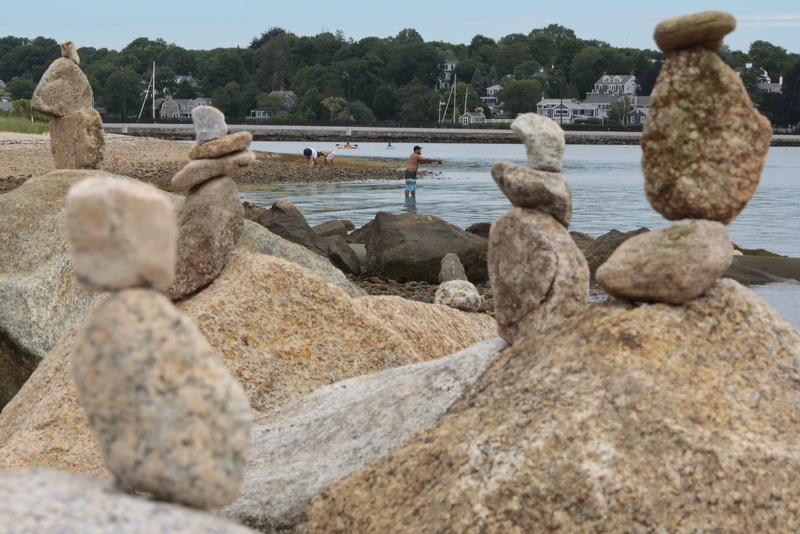 A man casts into Apponagansett Bay as in the foreground a series of rocks placed on top of each other can be seen lining the beach on Smith Neck Road in Dartmouth, MA. PHOTO PETER PEREIRA