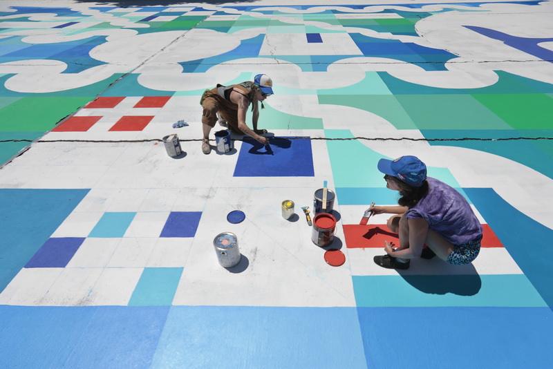 Laura Ganci, left, and Maria Molteni paint the basketball court at the Clasky Common Park in New Bedford, MA, as part of the Creative Courts program hosted by the New Bedford Art Museum and ArtWorks! with artist Maria Molteni.  PHOTO PETER PEREIRA