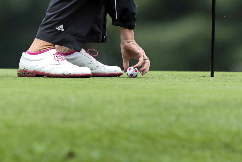 Barbara Grubkemeyer picks up her soccer themed golf ball, after missing the hole by mere inches on the 5th hole in the final round of the Country Club of New Bedford women's four ball.    PHOTO PETER PEREIRA