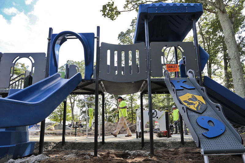 Matt Brow, center and fellow Norm Corp Construction workers install the new K9 Sgt. Sean Gannon playground at the Elwyn G. Campbell school in the north end of New Bedford, MA.  The new playground is expected to be complete by the end of the month.   PHOTO PETER PEREIRA