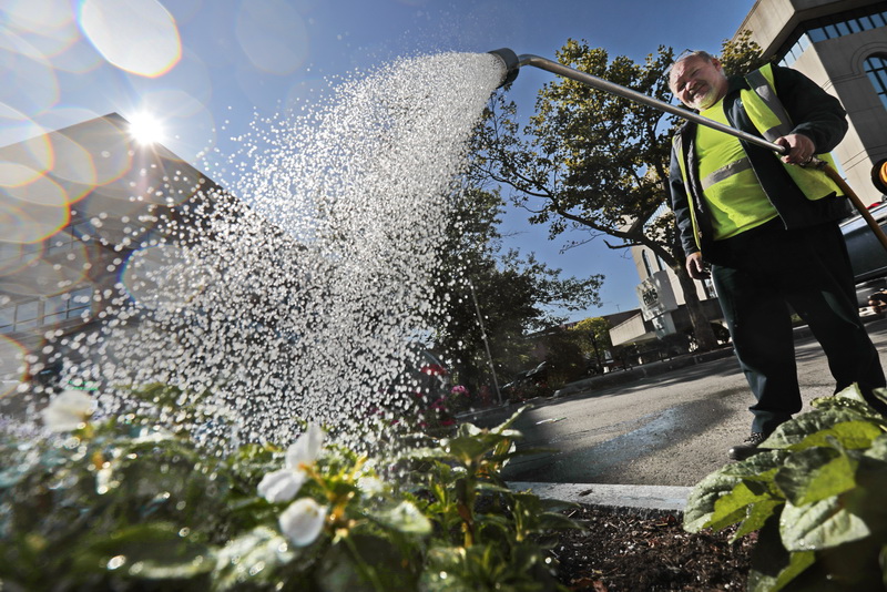 New Bedford's DPI's Ariel Perez waters some of the plants lining Union Street in downtown New Bedford, MA.  PHOTO PETER PEREIRA