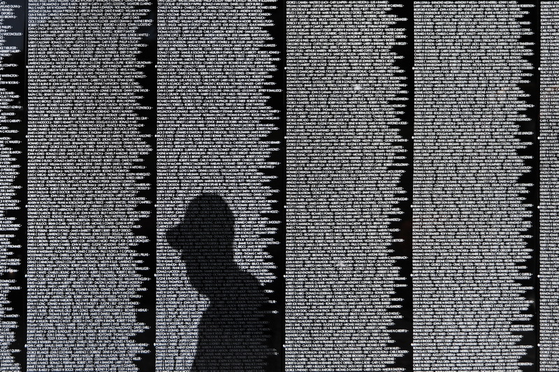 Vietnam veteran, Armand Perrault 69-70, looks for his friends name on The Moving Wall, a one half-size replica of the Vietnam Veterans Memorial in Washington DC.  The Moving Wall is currently on display at Highland Park in Attleboro, MA until Monday. PHOTO PETER PEREIRA