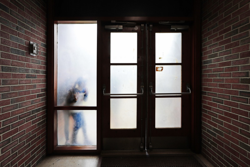 Elwyn Campbell Elementary school students playing during recess, are seen through the frosted windows on the doors inside the polling station, hosted by the school during elections in New Bedford, MA.  PHOTO PETER PEREIRA