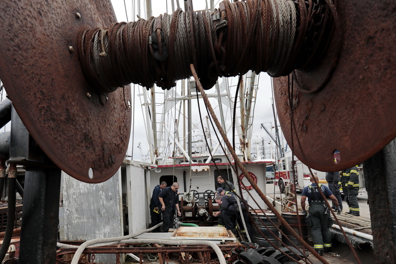 New Bedford firefighters attempt to pump out the water that had accumulated below deck aboard the Izabella Rose fishing boat docked in New Bedford, MA.  PHOTO PETER PEREIRA