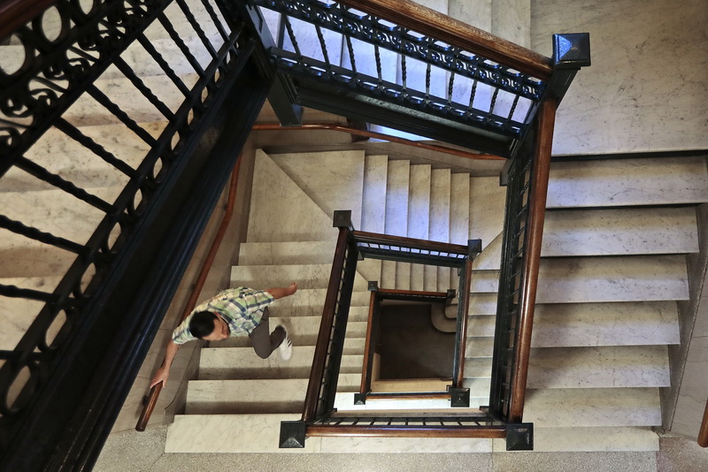 A man makes his way up the central marble staircase at City Hall in New Bedford, MA. 