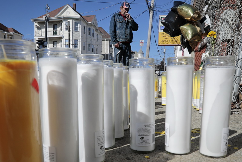 John Andrade, who lives close by, takes a moment to say a prayer as he walks by the intersection of Tallman Street and Ashley Boulevard in the north end of New Bedford, MA where two men were shot, one fataly, on Saturday evening.