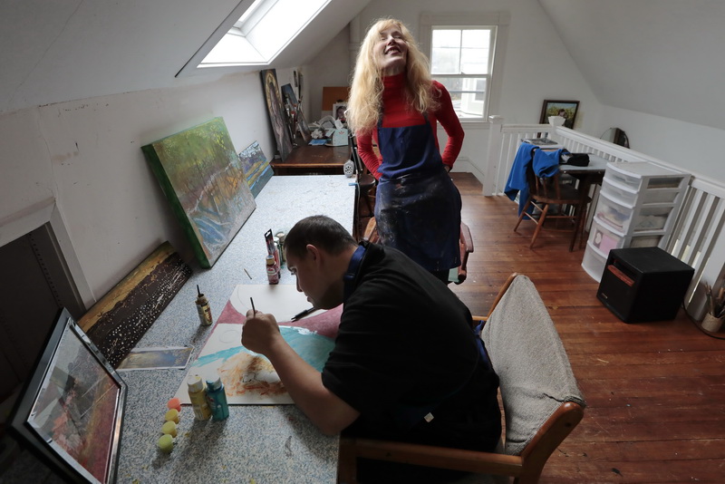 Artist Deborah Macy enjoys a good laugh at something David says as he works on his painting.  David Danis, who has Down syndrome, attends his weekly art class with local artist Deborah Macy at her studio in New Bedford, MA.