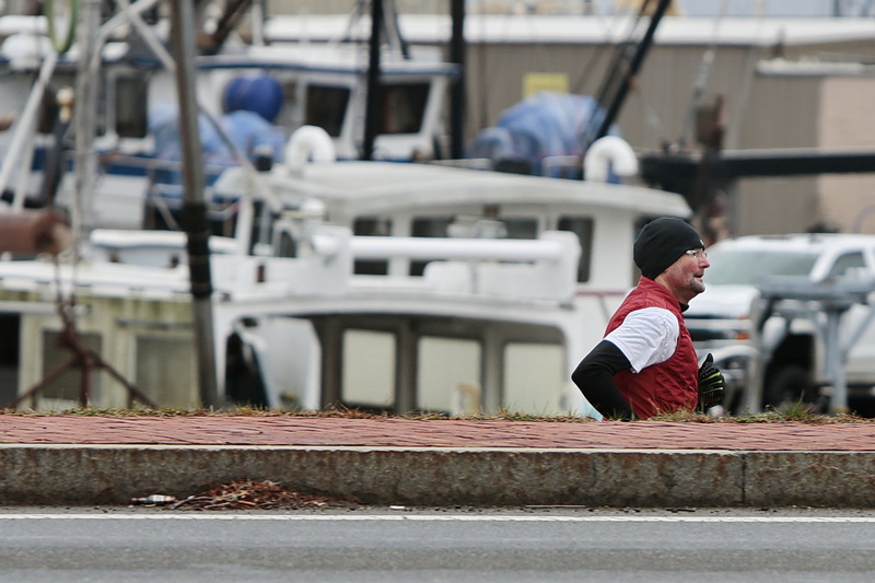 A man goes for a morning run on the lower sidewalk between Route 18 and  MacArthur Drive in downtown New Bedford., MA.