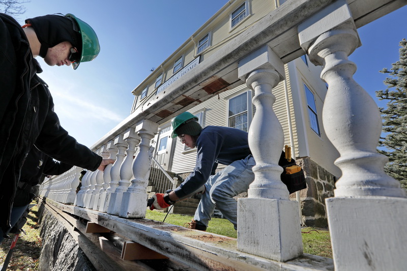 Greater New Bedford Vocational Technical High School students Jordan Buhour, left, and Jacob Cote,   remove the rail in front of the Mariners Home in downtown New Bedford, MA before bringing it back to their shop to repair it, as part of the Off Campus Construction class. 