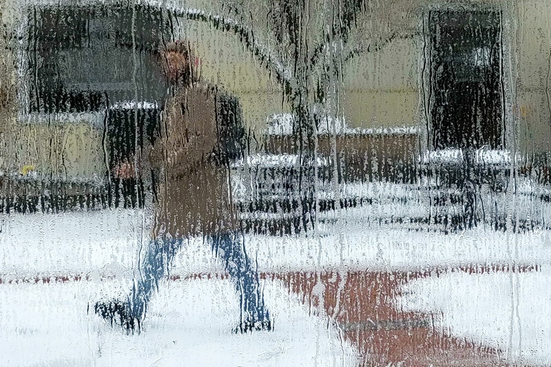 A man walks past the windows of Destination Soups in downtown New Bedford, MA as the snow that fell across the region begins to melt, leaving long streaks on the windows.   PHOTO PETER PEREIRA