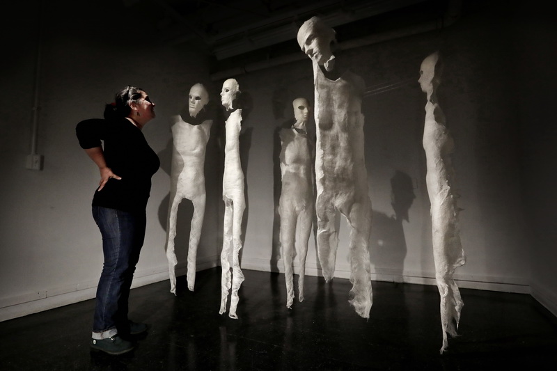 Paulina Fuenzalida works on installing her art project entitled 'Glint', to be evaluated by professors on Wednesday at the UMass Dartmouth Center of Visual and Performing Arts in downtown New Bedford, as part of her Master in Fine Arts degree final.  The piece is made up of mannequins she made using cotton, connected by fishing line, with glimmer, to create a layer of interaction between the mannequins and the viewer.  PHOTO PETER PEREIRA