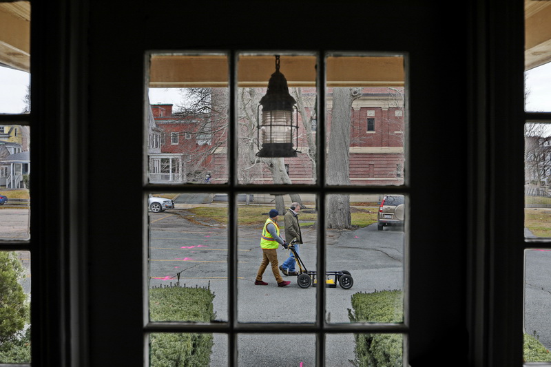 Seen through a window of the James Arnold Mansion in New Bedford, Radar Solution International VP Cameron Russ, and Tom Elmore of the Geonav Group, survey the area around the Wamsutta Club using ground penetrating radar, in an effort to 'see' which clues to the past still lay unseen below the surface of the parking lot. 